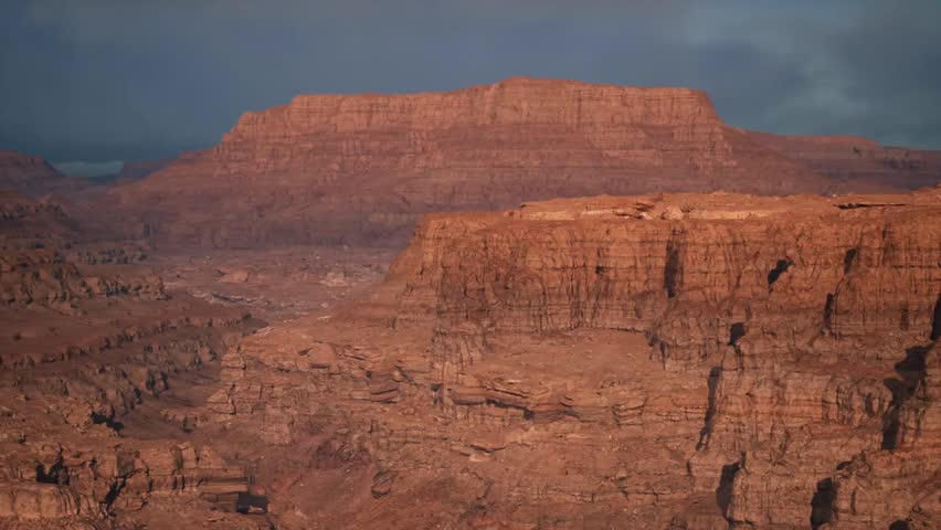 Sunny view of the Grand Canyon in Arizona, showcasing vast canyon cliffs, layered rock formations, and breathtaking natural landscape under clear skies.