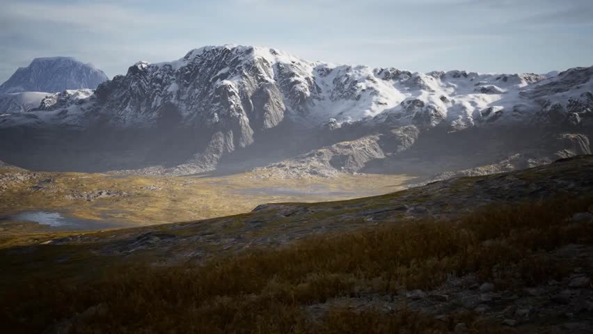 Snow-covered mountains contrasting with dry hills in Chile, showcasing a dramatic natural landscape with rugged terrain and diverse climates.