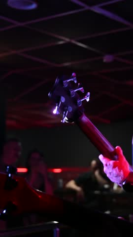 Rock musicians play guitars in a bar. 