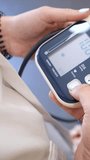 Closeup of a healthcare professional using a digital tonometer to check a patient's blood pressure, with the systolic reading increasing on the monitor during the cardiovascular examination - Powered by Shutterstock - Get 15% off with code: PIKWIZARD15