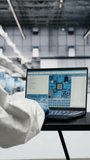 Vertical video Assessing hardware fabrication, laptop software and engineer in automated microchip foundry. Designing semiconductor manufacturing plant layout, notebook and expert, camera B - Powered by Shutterstock - Get 15% off with code: PIKWIZARD15