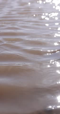Muddy road with puddle outdoors on sunny day, closeup