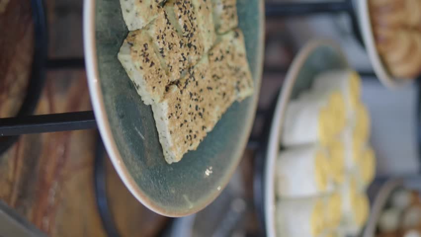 Close up shot of assorted appetizers including salty cookies and stuffed rolls during gourmet catering event buffet.