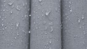 Water beads on gray water repellent fabric in closeup, highlighting waterproof textile texture and moisture protection - Powered by Shutterstock - Get 15% off with code: PIKWIZARD15