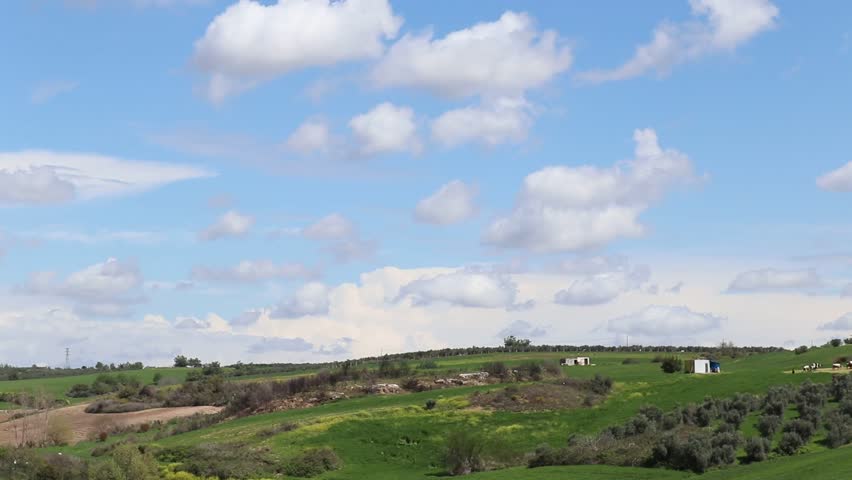 Scenic Rural Landscape Under Cloudy Sky, Wide view of a rural landscape with green fields under a dramatic cloudy sky.