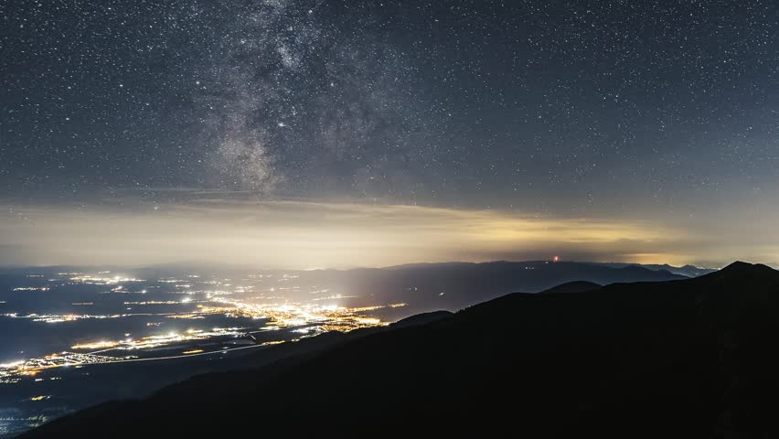 Milky Way Galaxy Stars in Night Sky over City Traffic and Mountains, Astronomy Time lapse