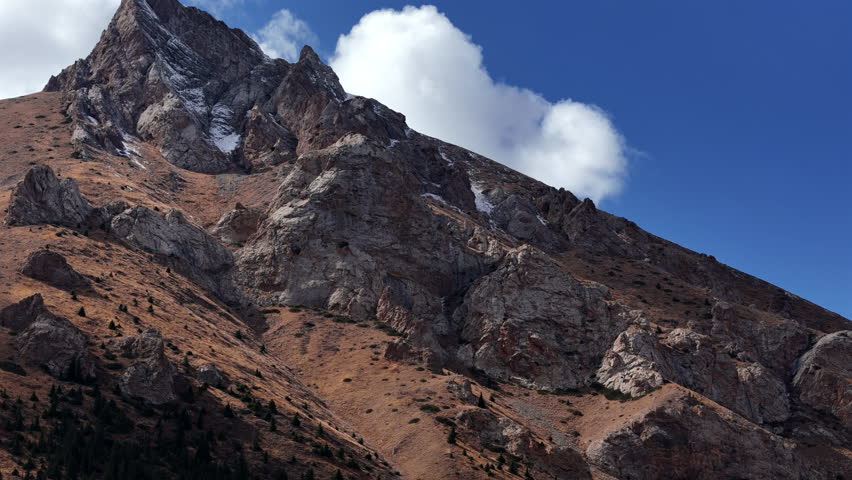 Rocky Mountain Peak with Snow Patches under Blue Sky