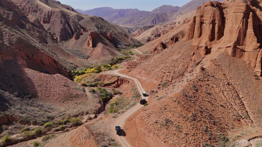 Offroad Cars on Winding Road Konorchek Canyons Kyrgyzstan Aerial View