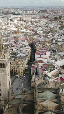 Vertical aerial capturing the iconic Seville Cathedral, a UNESCO World Heritage site, amidst the historic cityscape.