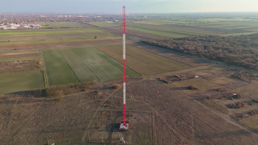 Lakihegy, near Szigetszentmiklós in Budapest, Hungary, features a prominent guyed steel radio mast used for medium-wave broadcasting, captured from above in a bird