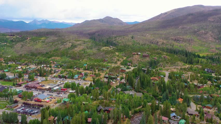 Aerial view of Payette Lake Idaho with hillside cabins, evergreen forest, winding roads, and rugged mountain scenery surrounding a scenic alpine residential area