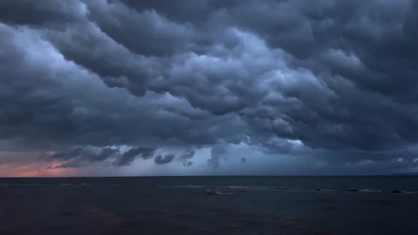 Dusk over turbulent sea with orange hues. Majestic dusk sky and crashing waves