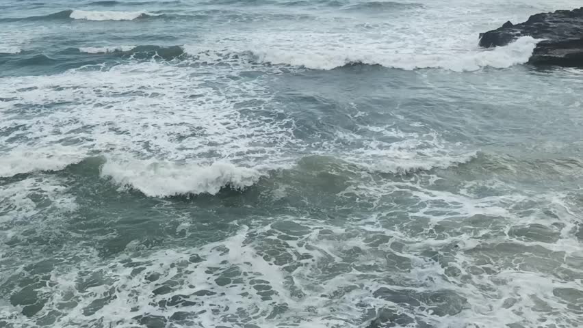 Dramatic ocean waves crashing on a rocky shore in Bali.