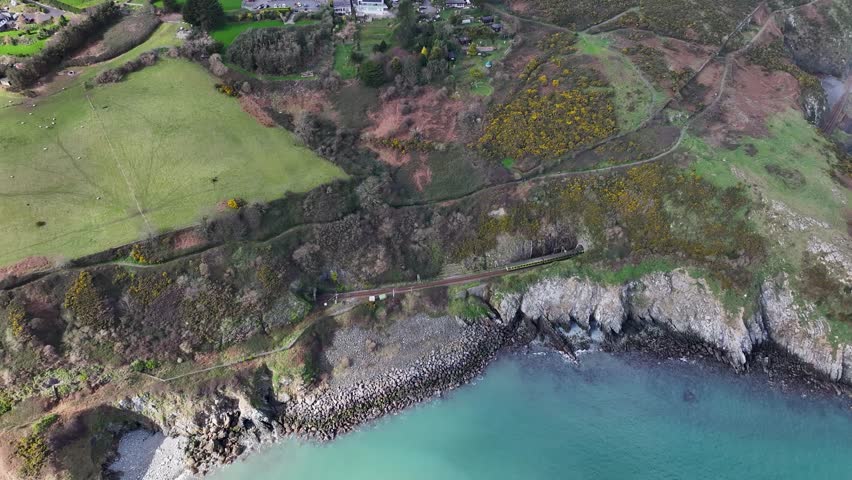 Train approaching tunnel aerial of coastal scenic train route, Irish Railway. Bray, Ireland.