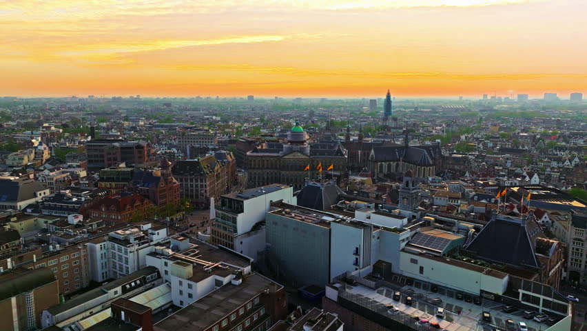 Aerial view of Amsterdam city at sunset, Netherlands. Amsterdam Central Station. Canals with boats in the center city, old centre 