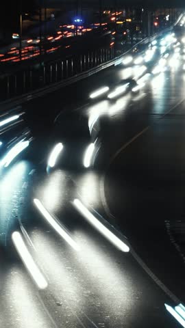 Dynamic Night Traffic Light Trails on a Curved City Highway. Vertical Time Lapse