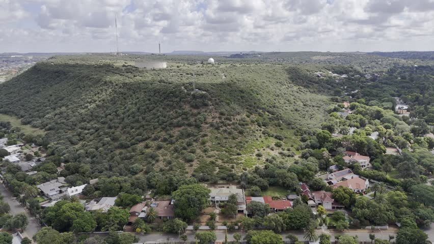 Drone flies west over Naval Hill toward the planetarium on sunny afternoon in Bloemfontein, South Africa