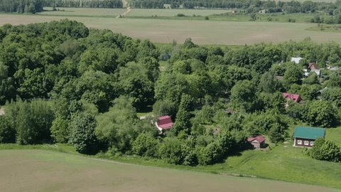 Drone Circling Upward above Village Forest Edge