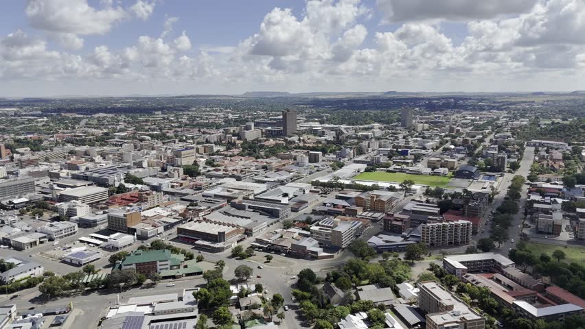 Drone flies west from Naval Hill toward city center on partially cloudy afternoon in Bloemfontein, South Africa
