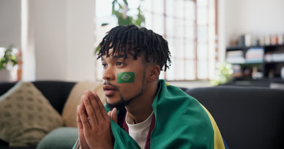 Man, sports and brazil flag in house for watching tv, football match loss or upset for game defeat. Disappointed, black person and broadcast in home with soccer world cup, stress or competition fail.
