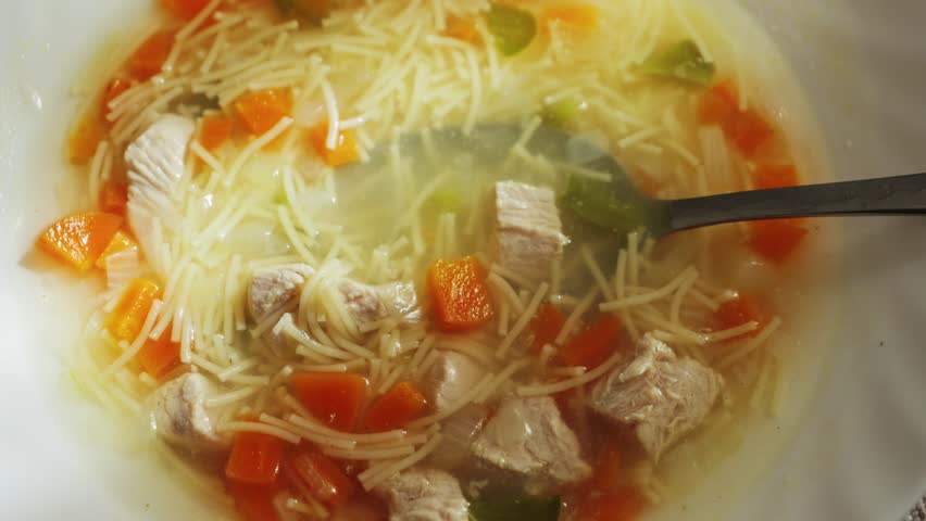 Aromatic delicious chicken noodle soup with vegetables. The concept of homemade food. High quality 4k footage