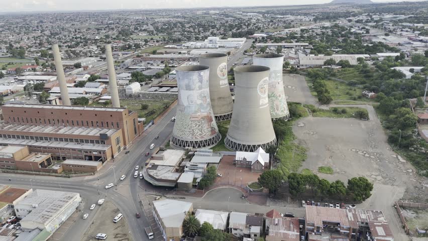 Drone flies over the four power station towers as camera pans down to look inside one tower on overcast afternoon in Bloemfontein, South Africa