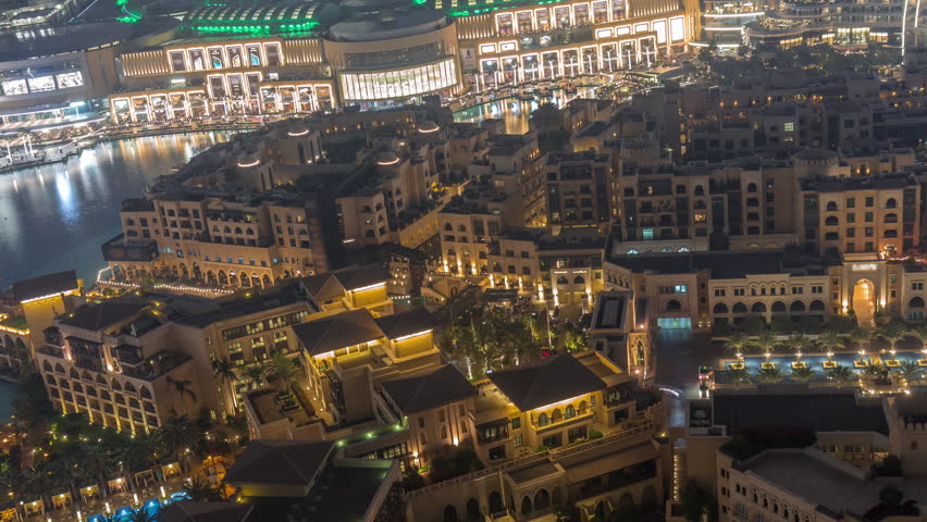 Traditional illuminated Old Town Island and fountains area near the mall and souk in Dubai Downtown. Aerial look down night view of architecture in time-lapse.