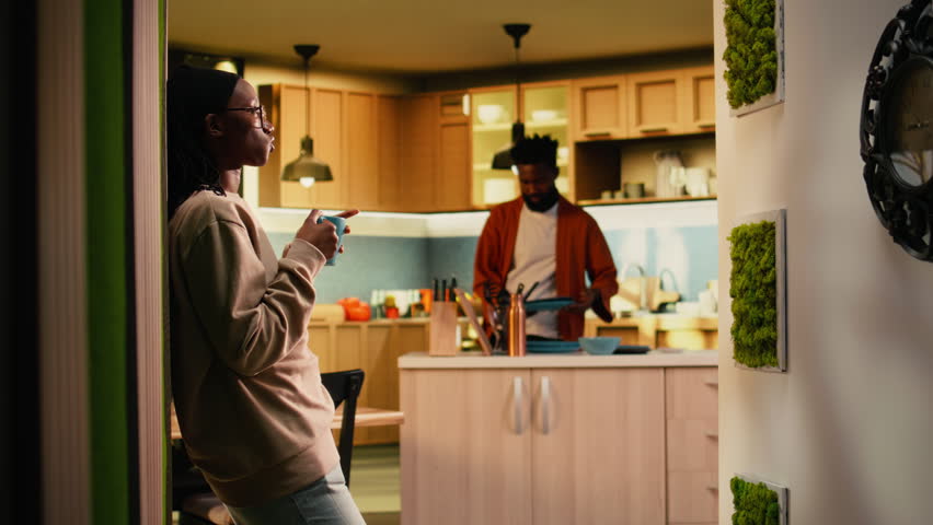 African american peaceful woman enjoying warm drink at the house, enjoying tea time with a reflective attitude. Young adult relaxing at home with soft light, serene natural peace.