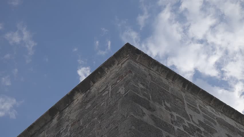 Low-angle shot of a building corner against a cloudy sky
