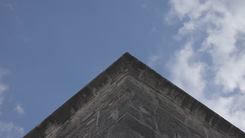 Low-angle shot of a building corner against a cloudy sky