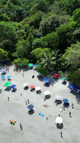 Aerial view of a white sand beach full of tourists on the Pacific coast of Costa Rica