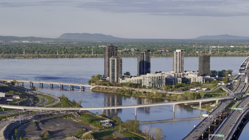 Ile-des-Soeurs Island residential buildings, bridge, and traffic at the sunset, Montreal, Quebec, Canada...