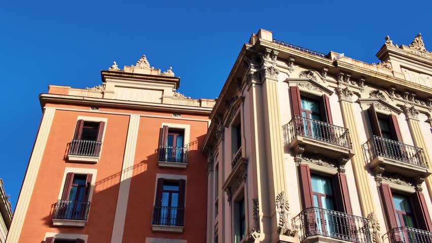 Historic building with ornate balconies and a religious statue on a corner of La Rambla in Barcelona, Spain