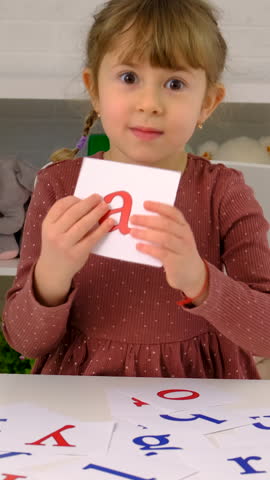 The child learns English letters. Selective focus. Kid.