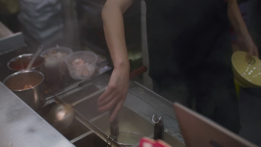 Delicious ramen noodles cooked in boiling broth using strainer, Asian street food and travel cuisine