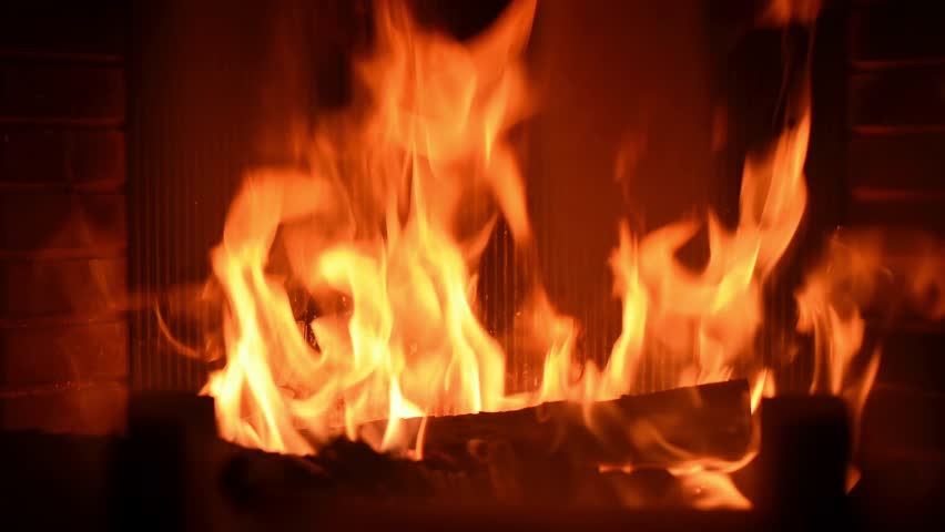Fireplace with burning logs creates warm atmospheric glow and cozy indoor ambience in slow movement.