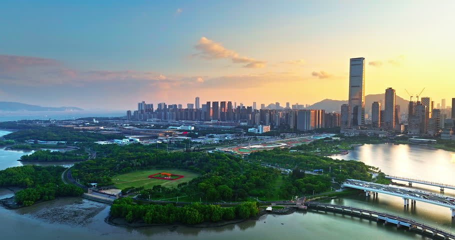 Aerial view of Shenzhen city skyline with modern skyscrapers and lush urban park at sunset, China. Financial district urban landscape.
