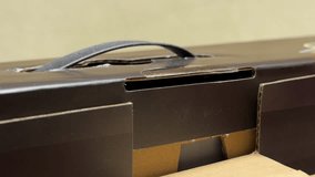 A close-up view shows a black cardboard box with its top flap partially open. The opening reveals a smaller, light-colored cardboard container nested inside. - Powered by Shutterstock - Get 15% off with code: PIKWIZARD15