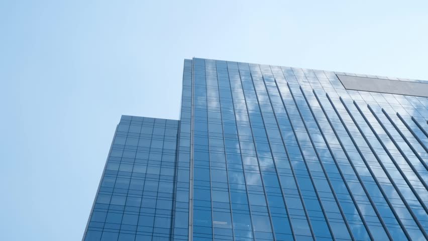 Modern business blue building against sky with clouds, time lapse.