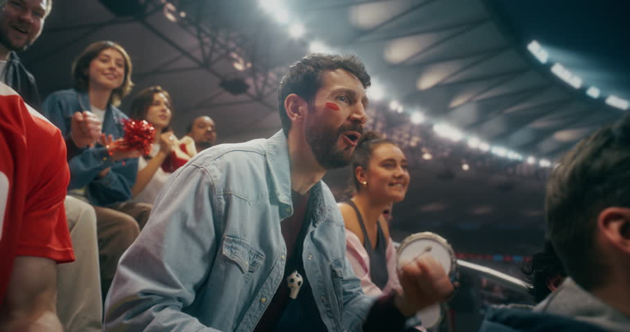 Portrait of a Happy White Male Soccer Fan With Face Paint Cheering, Smiling and Raising His Fist With Fellow Supporters in a Packed Stadium During a Professional International World Event, Slow Motion