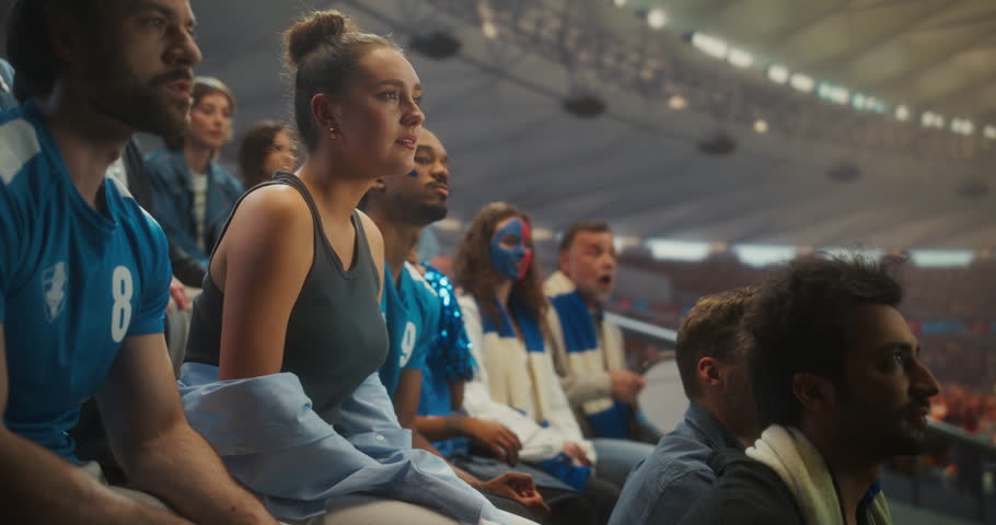 Disappointed Soccer Fans in a Packed Open Stadium React After a Crushing Loss, Shifting From Hope to Heartbreak. Diverse Supporters in Blue Sit Stunned, Frustrated, and Emotionally Drained.