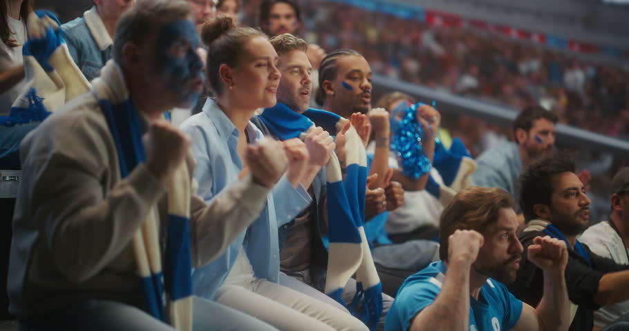 Close-up of Diverse Football Supporters Celebrating in a Packed stadium Smiling, Chanting and Raising Arms for Their Team During a Professional League Match and Major International Tournament.