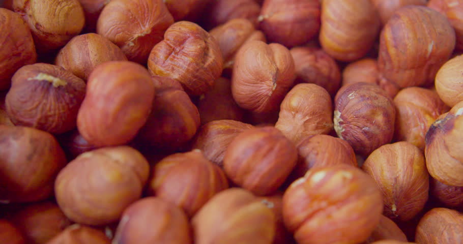 Peeled hazelnut kernels lie on a plate. Close-up