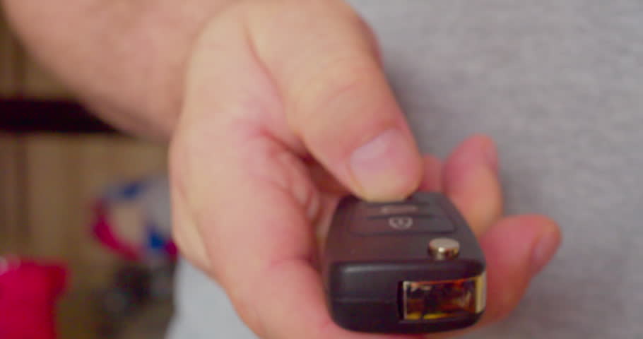 Close-up footage of a man’s hand unfolding a retractable car key