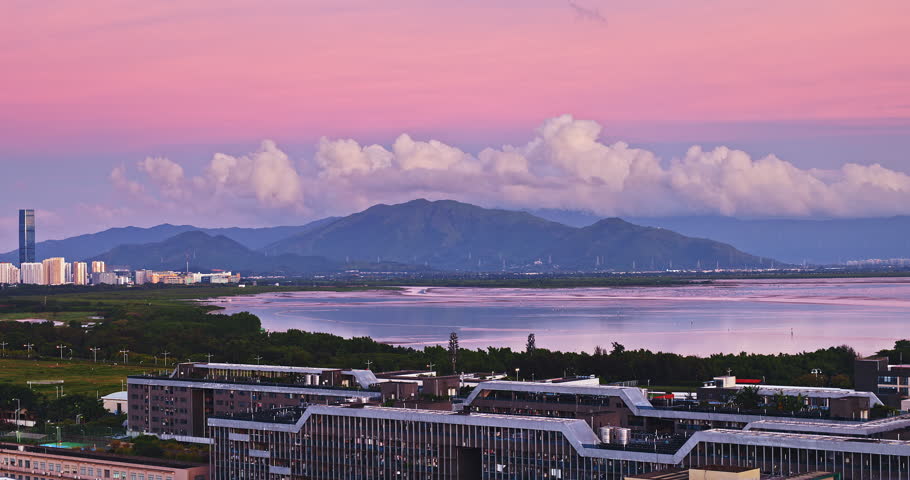 Stunning sunset view of Shenzhen coastal city skyline with mountains and lake under a pink twilight sky, China