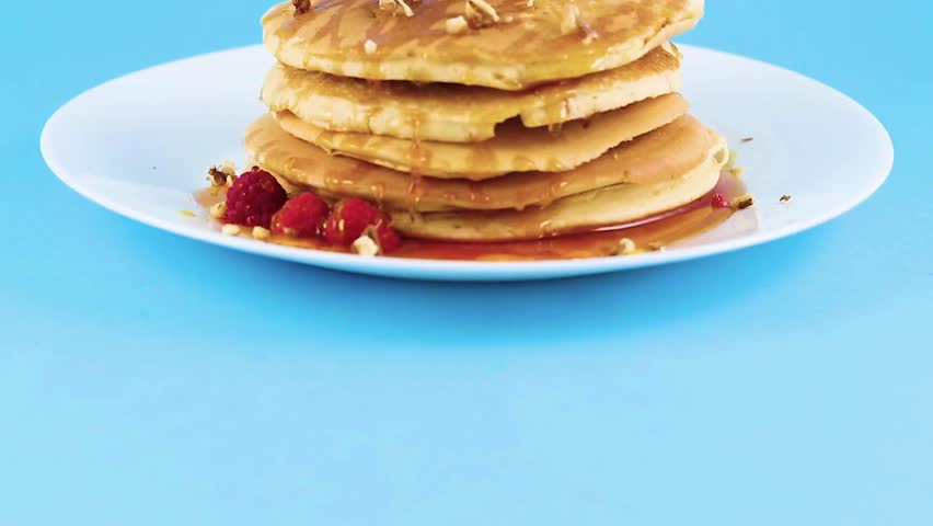 Tasty homemade pancakes with syrup and raspberries for morning breakfast. adds raspberries and syrup to pancake, uses new morning breakfast recipe.