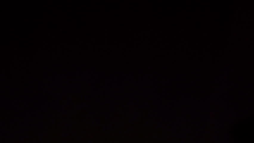 A bunch of pencils in many different colors. Moving slowly towards the camera in front of a black background.