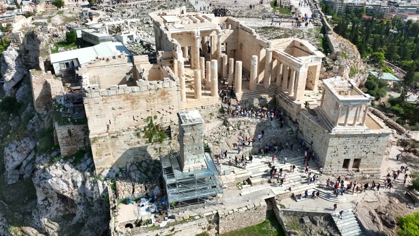 Aerial drone cinematic video of iconic Propylea or gate of Acropolis hill and the Parthenon, Athens historic centre, Attica, Greece