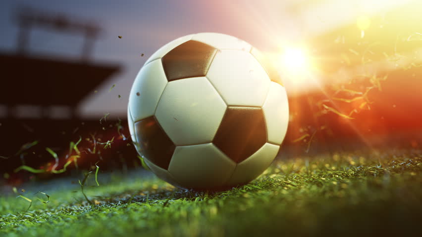 Glowing soccer ball on field at sunset