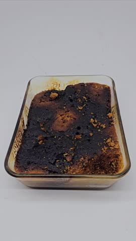 The cake batter was baked too long in its container, so it ended up burnt. Learning to make cake and burnt. Isolated on white background.
